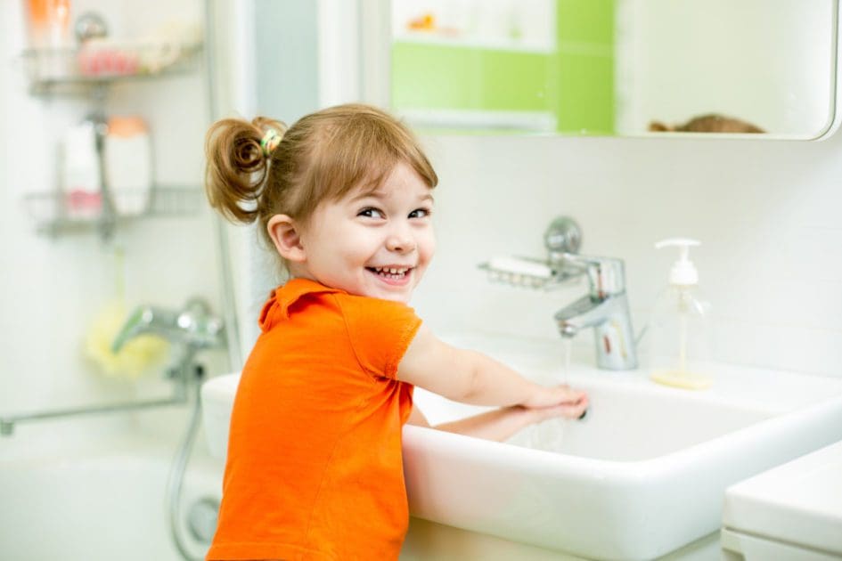 Cute kid girl washing in bathroom