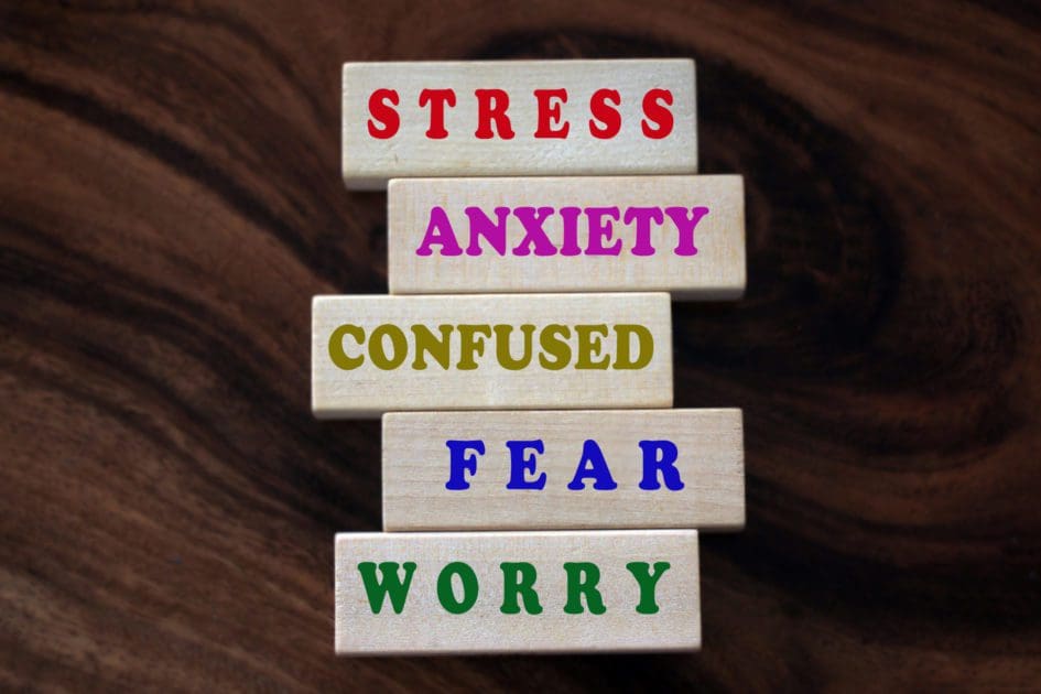 Mental health awarness concept with single words printed on wooden blocks - stress, anxiety, confused, fear, worry and all negativity.
